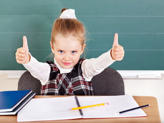Schoolchild in classroom near blackboard.