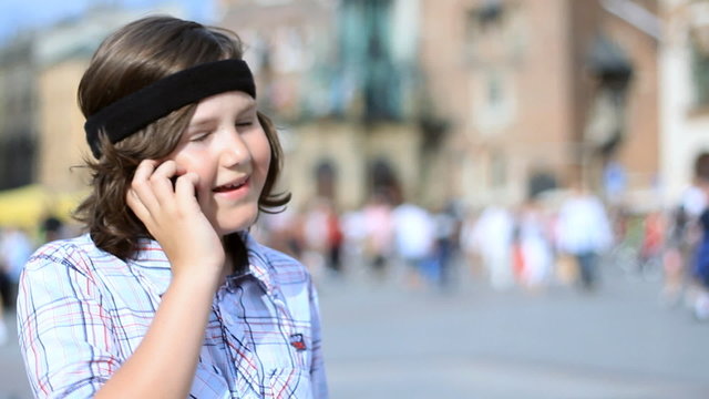 Young boy talking on mobile phone in the city