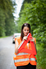 Young female driver wearing a high visibility vest/safety vest,