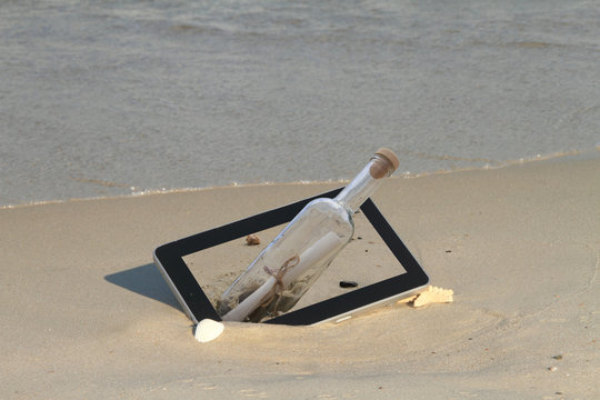 Tablet computer on the beach, with a message inside