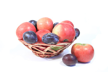 Basket with fruit: apples and plums.