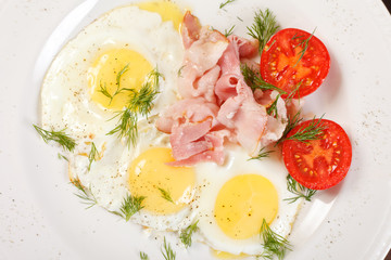 fried eggs with bacon and vegetables