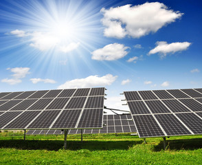 Solar energy panels against blue sky with clouds