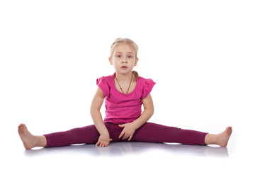 Studio portrait of girl gymnasts, sitting on the splits