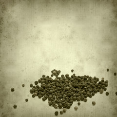 textured old paper background with black peppercorns