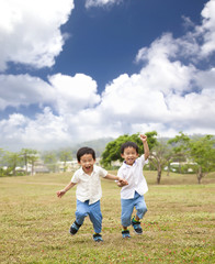 Fototapeta premium happy asian kids running on the grass