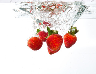 Strawberries dropped into water splash