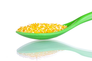 corn grits in green plastic spoon isolated on white