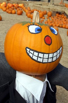 Painted pumpkin head on pumpkin patch