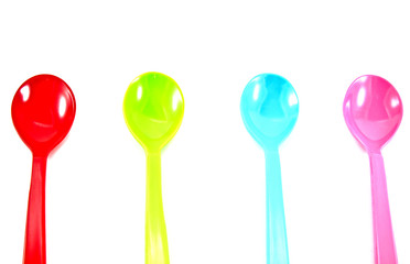 Colorful plastic spoons on white background
