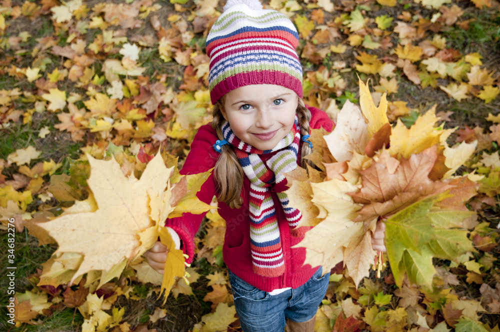 Wall mural autumn - little girl playing in autumn park