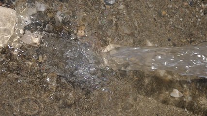 falling water of source on a sand - Powered by Adobe
