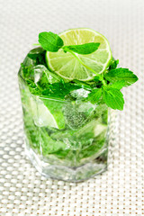 Alcoholic beverage of lime and mint in glass