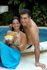 Pareja comiendo en la piscina.
