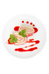 sponge cake roll with strawberry cream on a plate isolated on wh
