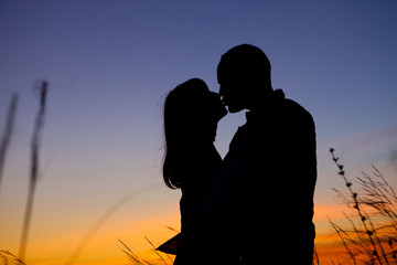 Couple on the sunset background.