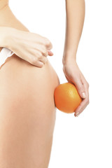 Slim woman shows the fig to cellulite, isolated on white backgro