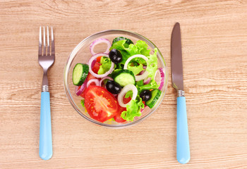 salad of fresh vegetables in a plate and cutlery