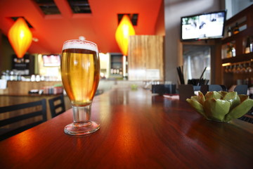 Glass of beer on a bar counter.