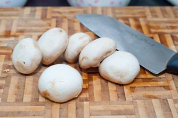 mushrooms on wooden chopping board .