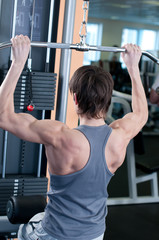 Naklejka premium Powerful muscular man lifting weights in gym