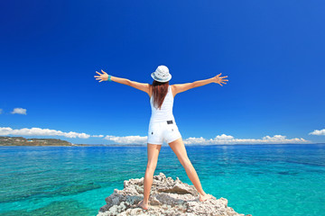 海に向かって大きく手を広げる女性