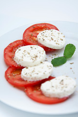 Ensalada de tomate y queso mozarella en fondo blanco