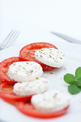 Ensalada de tomate y queso mozarella en fondo blanco