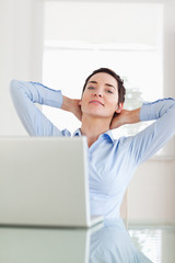 Relaxed businesswoman with a laptop looking into the camera