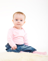 eight-monthly girl in a pink jacket and jeans