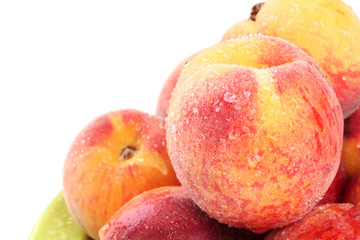 Fresh peaches with water drops on white
