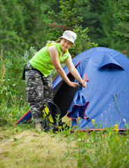 female hiker in front of camp