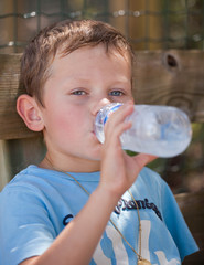 Enfant buvant de l'eau à la bouteille