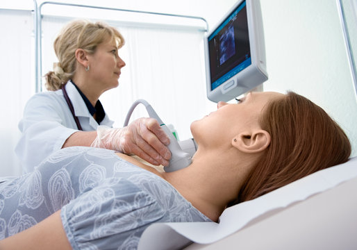 woman getting ultrasound of a thyroid from doctor