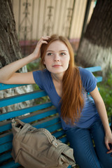 sad girl sitting on a park bench