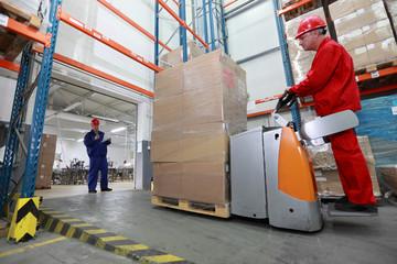 Goods delivery - two workers working in storehouse