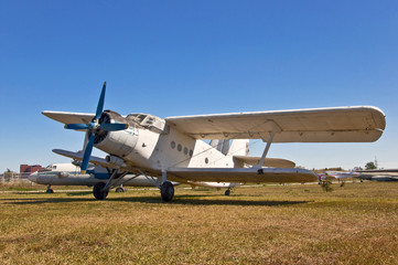 Fototapeta na wymiar stary rosyjski samolot na trawie i niebieskim tle nieba
