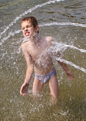 Мальчик купается в городском фонтане