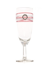 empty glass with pink ribbon and ring on it