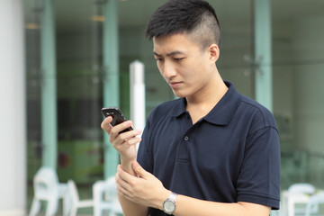 Fototapeta na wymiar Asian man typing a message on mobile phone.