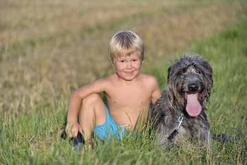 Kind mit Hund auf Wiese