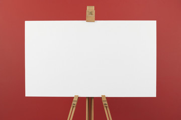 Artist's canvas on easel, red background