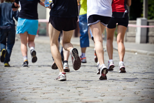 People running in marathon on city street