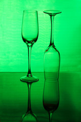 Two tall wineglasses on a green background