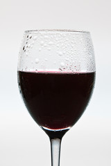 Closeup red wine glass with drop isolated