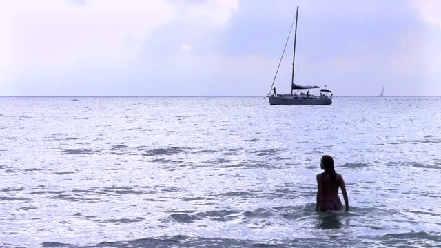 vela, motoscafo e donna che si tuffa nel mare