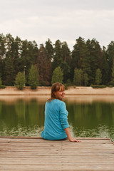 Fototapeta na wymiar Young woman sitting on jetty