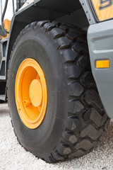 Black wheel with yellow disk of front loader