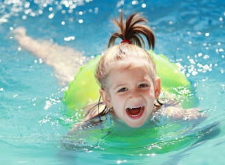 Fototapeta na wymiar Child swimming happily in pool