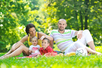 happy young couple with their children have fun at park